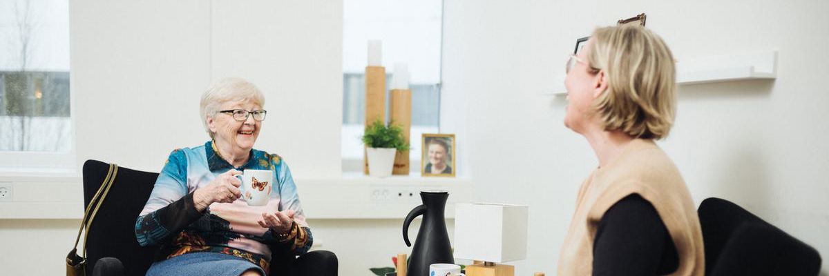 Forebyggende hjemmebesøg, foto af 2 kvinder i en samtale i hver sin lænestol