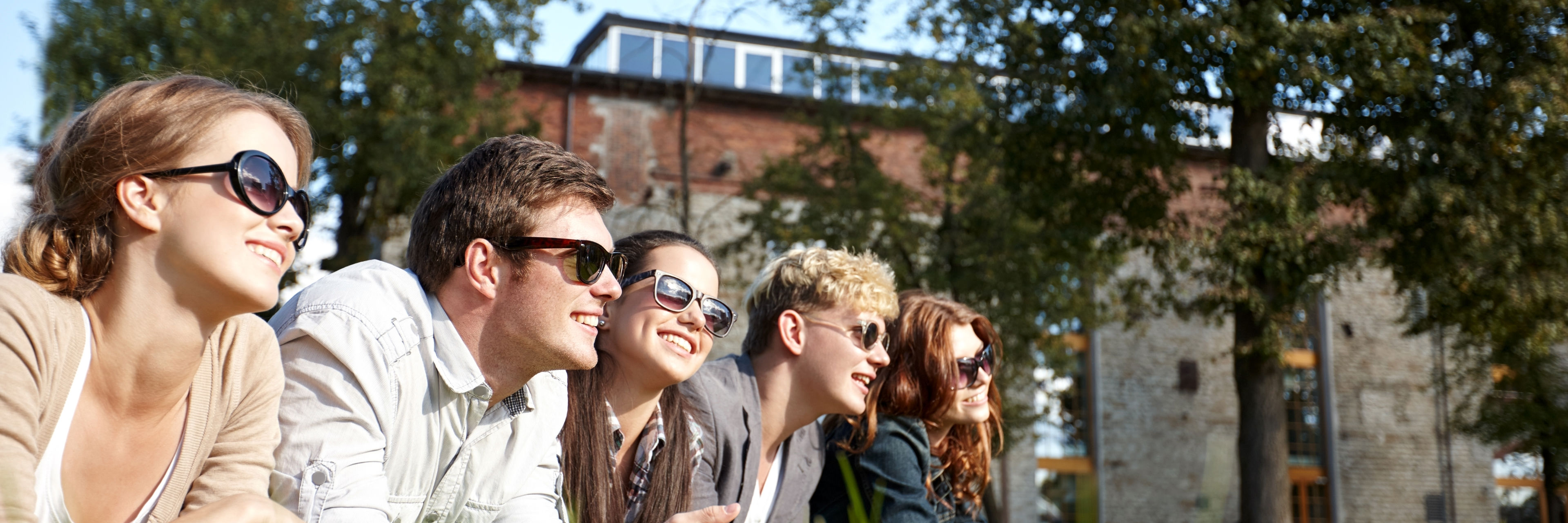 Foto af en gruppe unge mennesker der ligger på en græsplæne