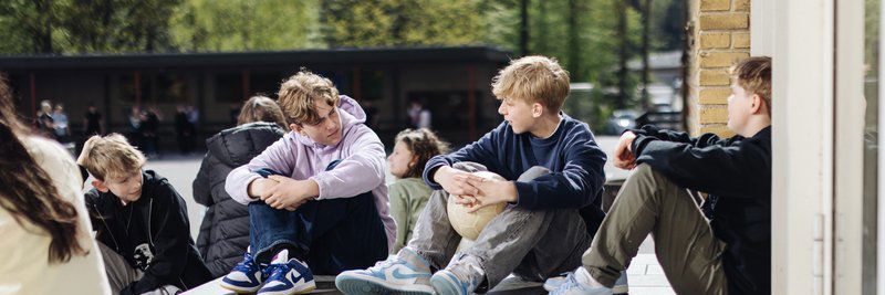 Drenge i skolegård med fodbold