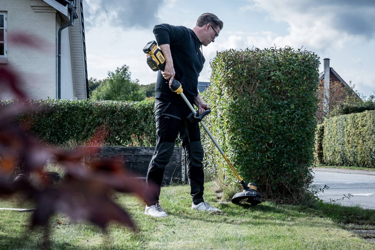 Tomas arbejder med en græstrimmer i forhaven.