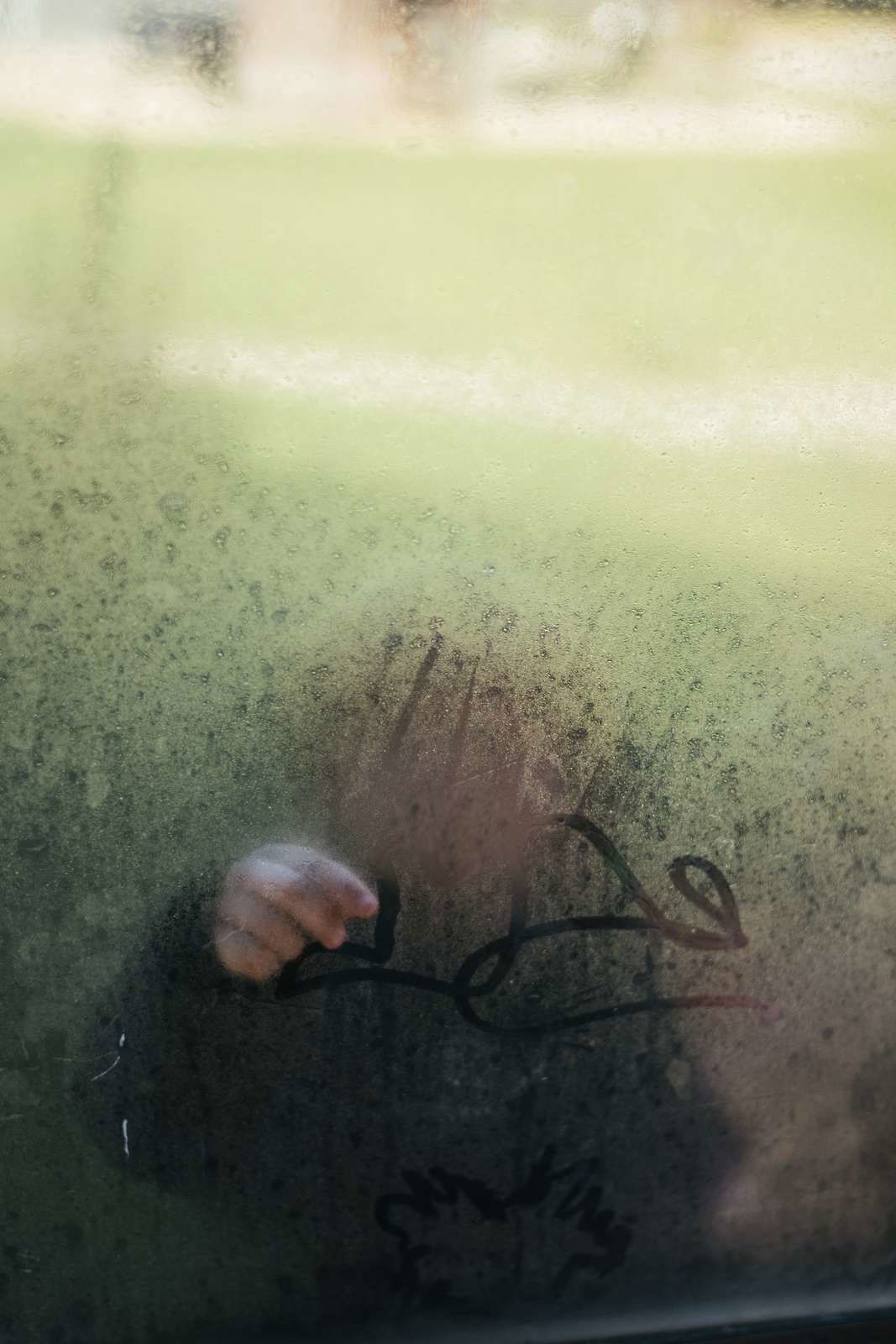 Billede af barn bag en dugget rude