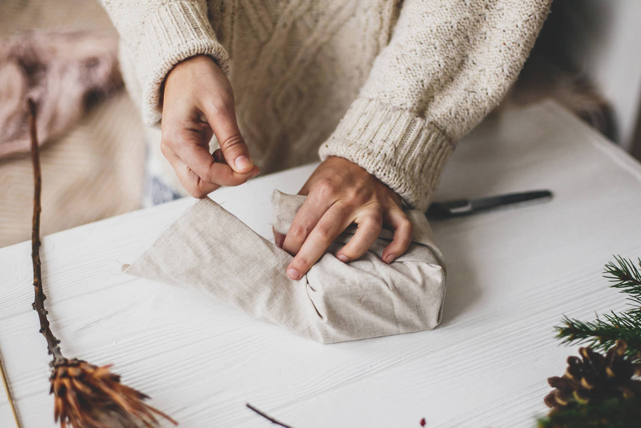 Bæredygtig julegaveindpakning med stof i stedet for gavepapir – en miljøvenlig løsning med naturmaterialer som pynt.