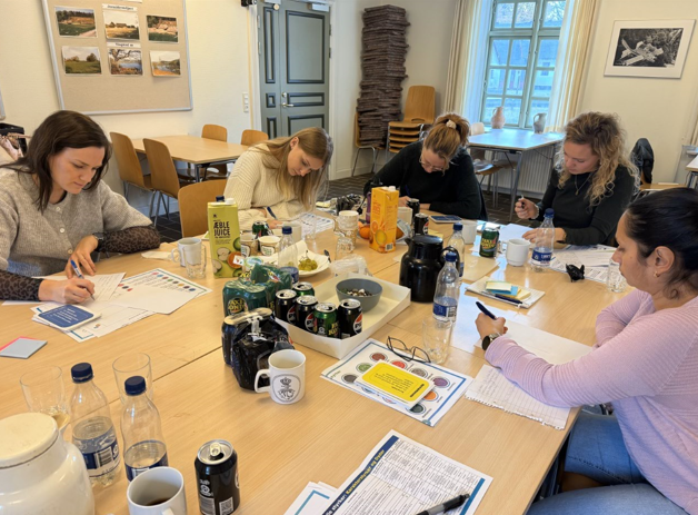 Her arbejder kontoreleverne individuelt siddende rundt om et bord