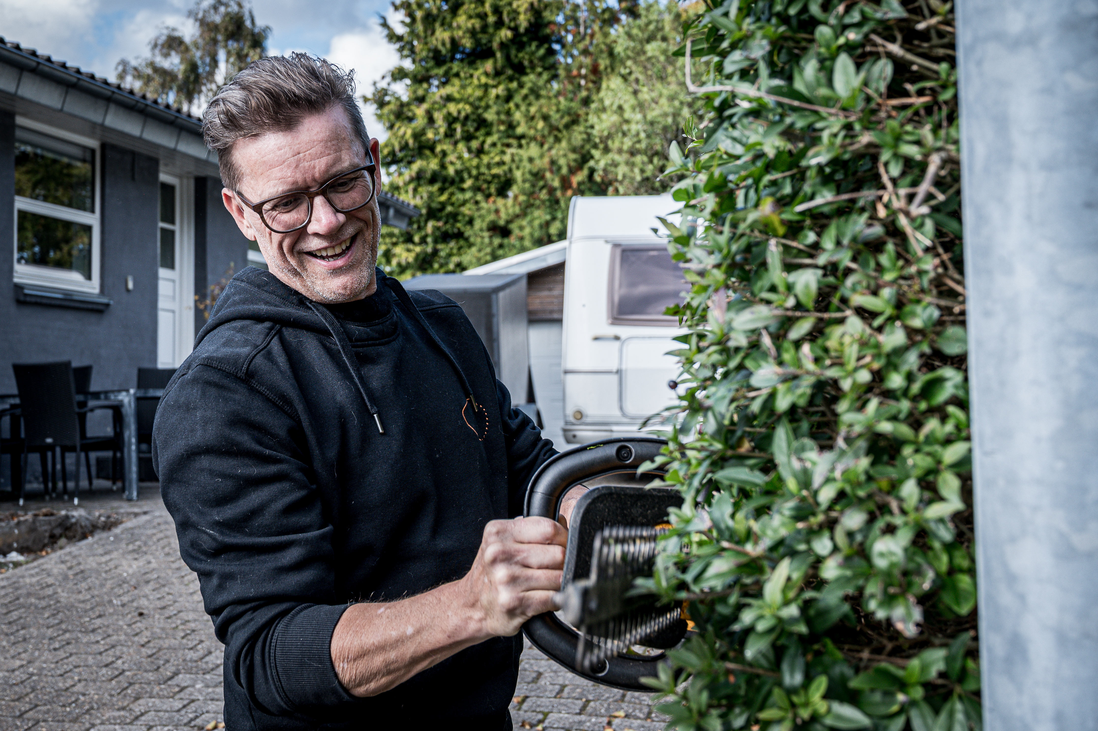 Tomas trimmer hæk med elektrisk hækkeklipper.