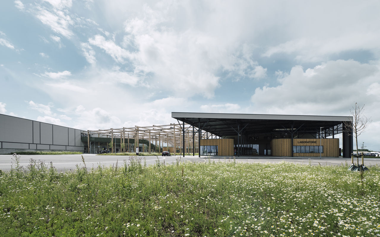 RessourceCenter Vejle (RCV) med grønt tag og solpaneler, omgivet af grønne områder, der viser centerets bæredygtige arkitektur og indre gårdstruktur.