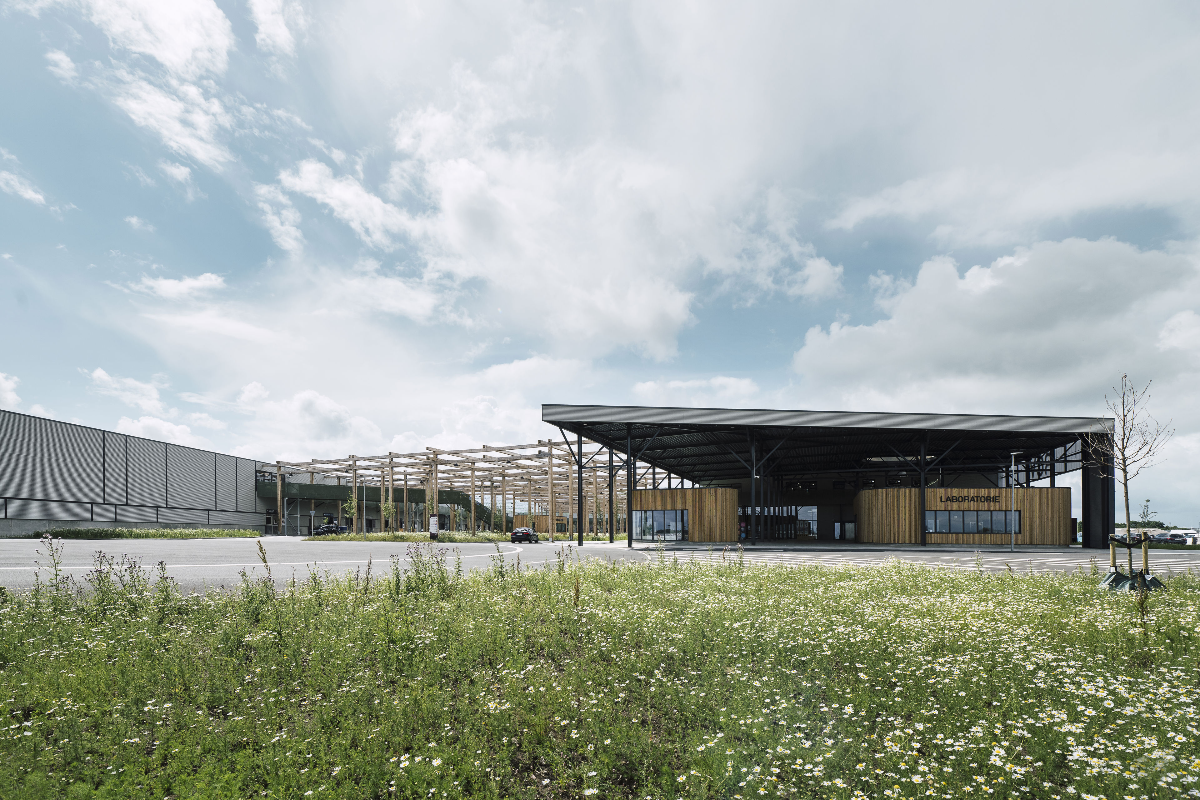 RessourceCenter Vejle (RCV) med grønt tag og solpaneler, omgivet af grønne områder, der viser centerets bæredygtige arkitektur og indre gårdstruktur.