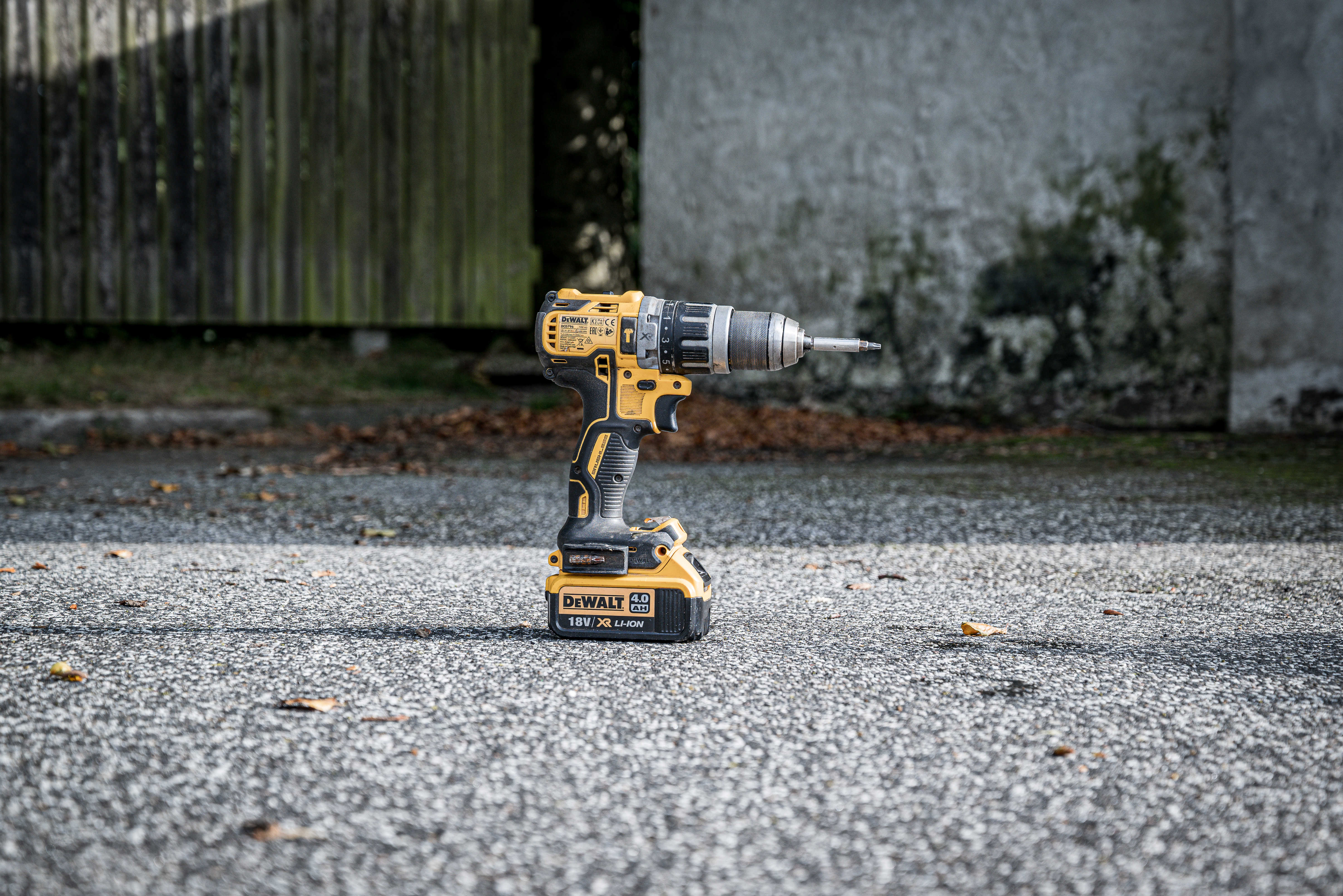 Boremaskine står på jorden foran et plankeværk.