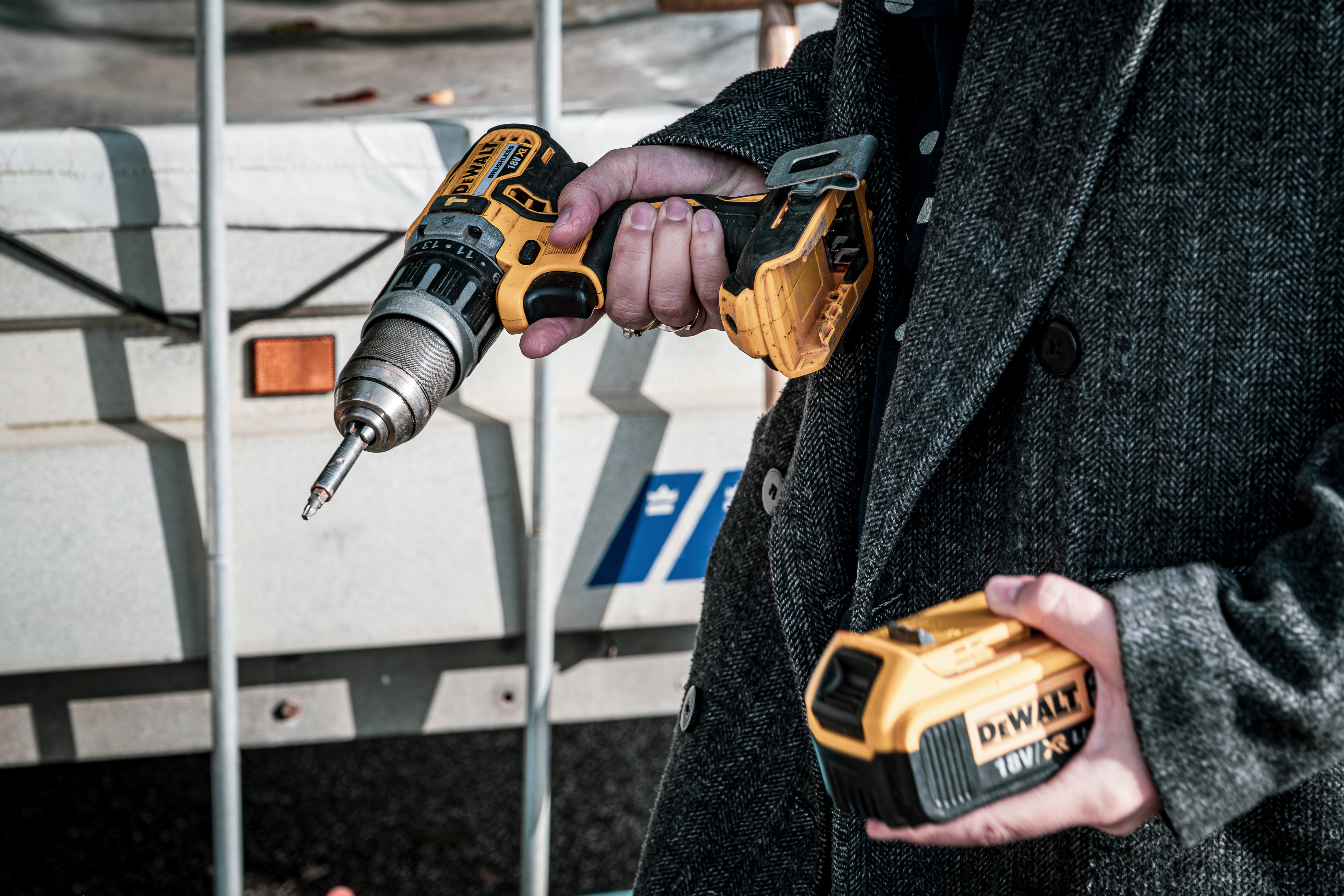 Nærbillede af en person, der holder en boremaskine og batteri.