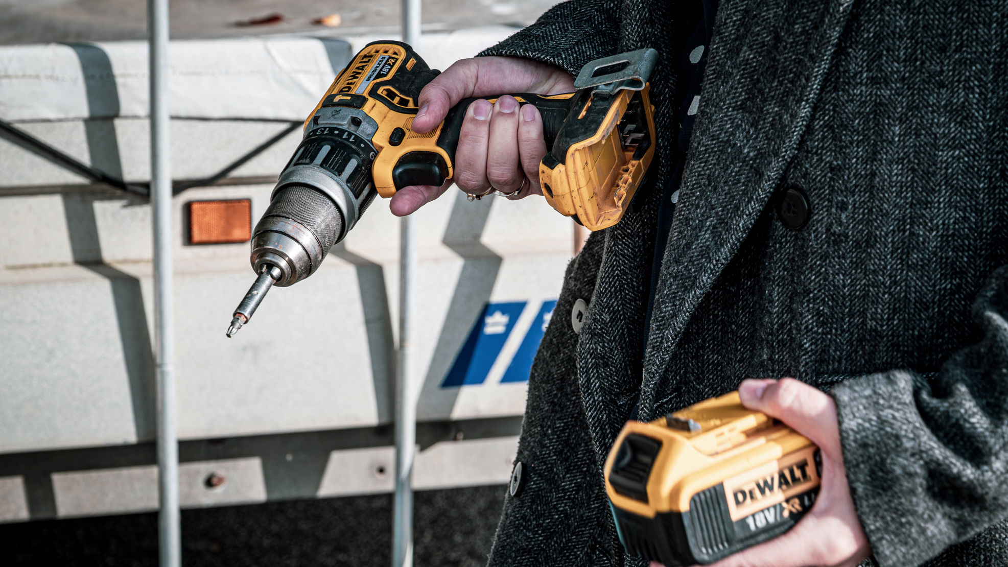 Nærbillede af en person, der holder en boremaskine og batteri.