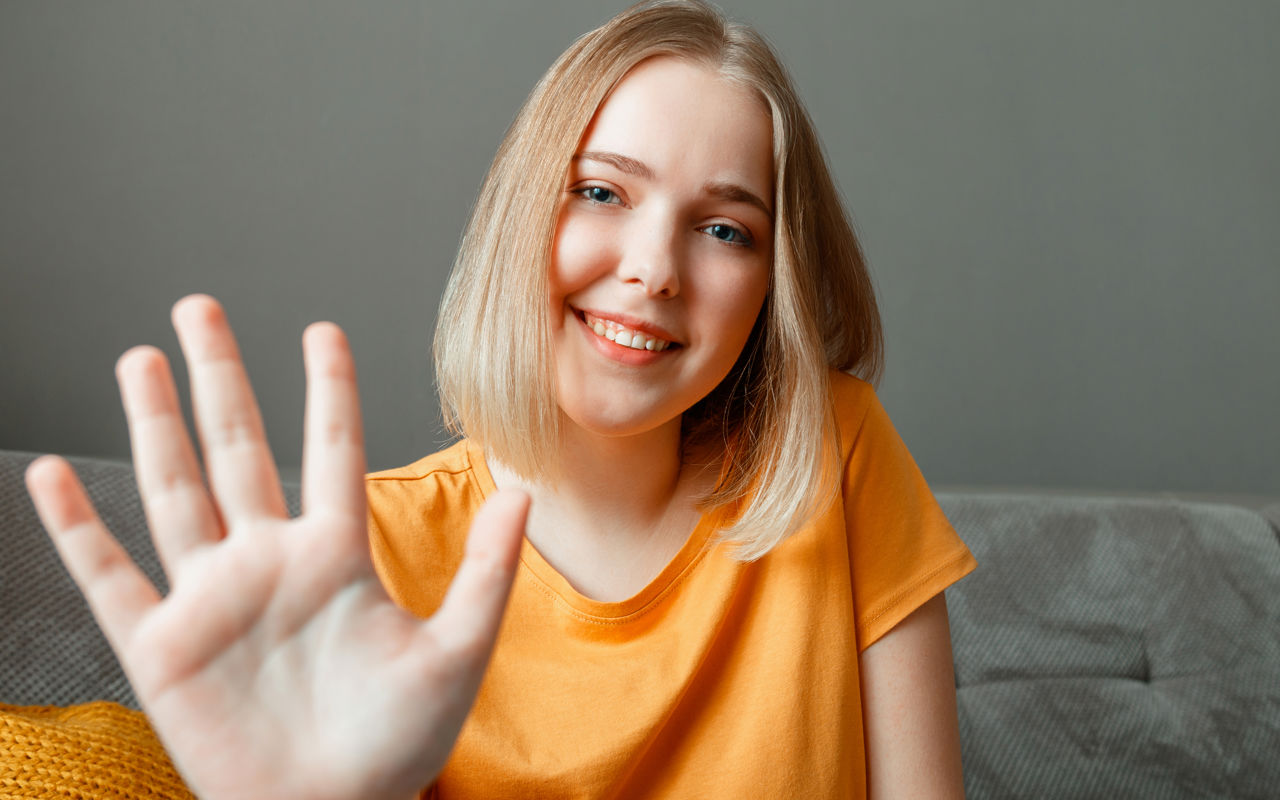 Ung smilende pige med en fremstrakt hånd