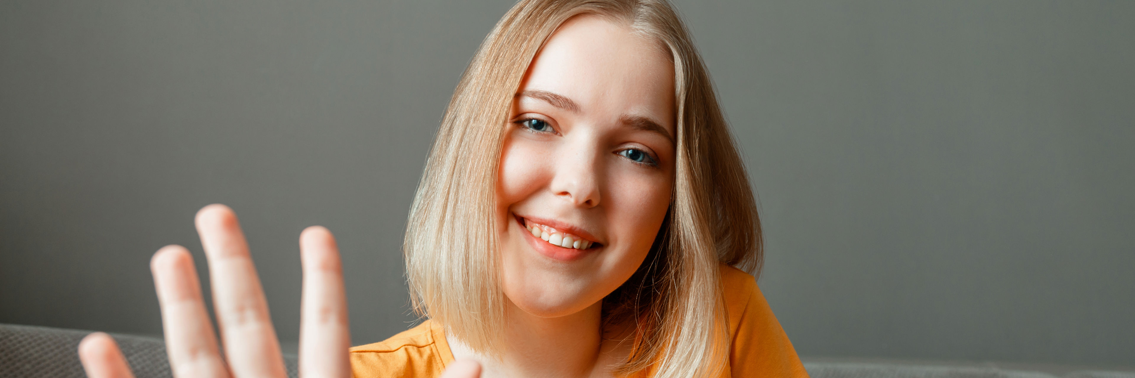 Ung smilende pige med en fremstrakt hånd