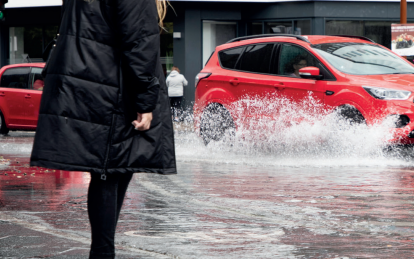 Biler der kører igennem en gade med højt vand