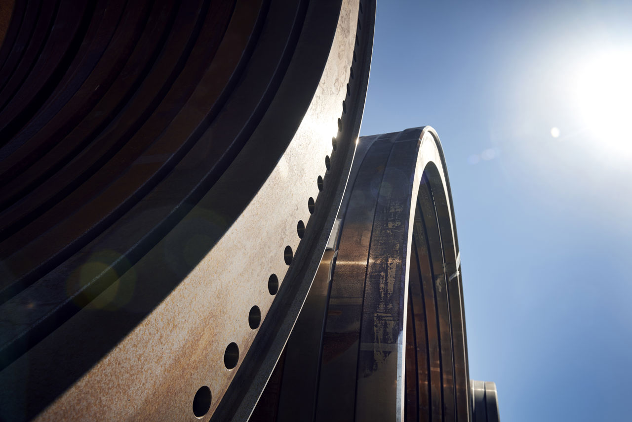 Vindemølledele på Welcon. Industridele, i baggrunden ses himlen og lidt sol.